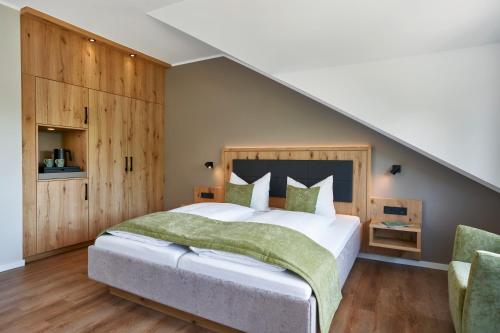 a bedroom with a large bed and wooden walls at Sporthotel Grafenwald 4 Sterne Superior in Daun