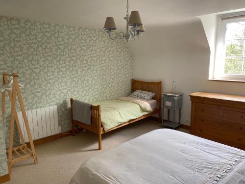 une chambre avec deux lits et une commode et une fenêtre dans l'établissement Chambre de Rose - Le Refuge des Parachutistes - en bordure du marais, à Neuville-au-Plain