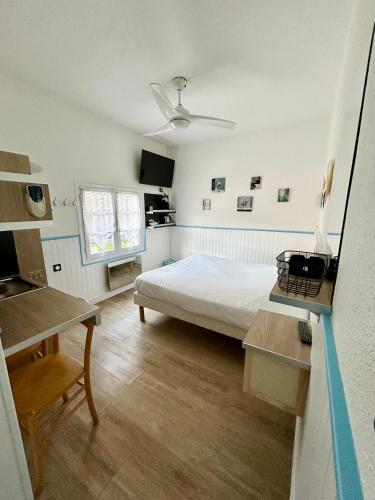 une chambre avec un lit, une table et un bureau dans l'établissement Hotel Oasis, à Argelès-sur-Mer