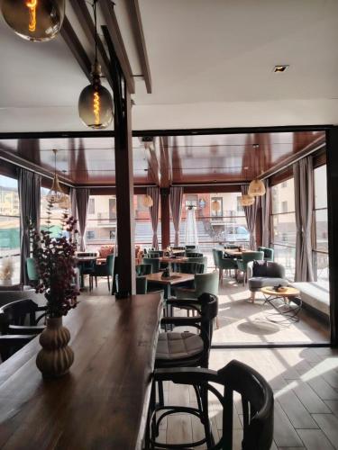 a restaurant with tables and chairs and a large window at All Seasons Residence in Zlatibor