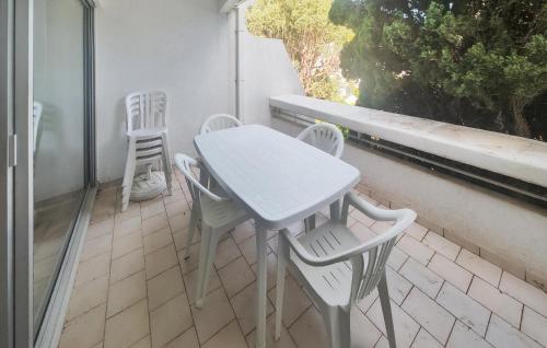 une table blanche et des chaises sur un balcon dans l'établissement Gorgeous Apartment In La Grande-Motte, à La Grande Motte