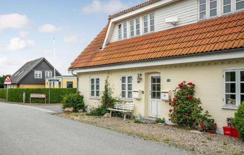 a white house with a bench in front of it at 3 Bedroom Amazing Home In Sydals in Østerby
