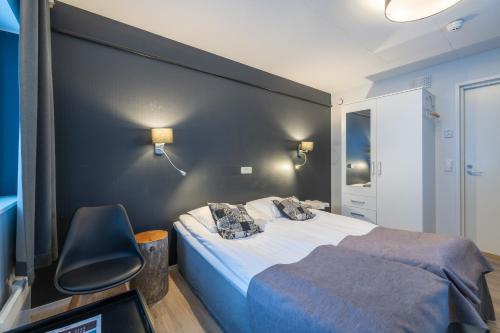 a bedroom with a large bed and a chair at Kuukkeli Saariselkä Inn in Saariselka