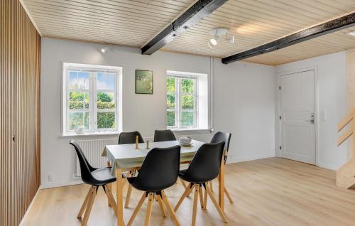 a dining room with a table and black chairs at 3 Bedroom Awesome Home In Sydals in Østerby