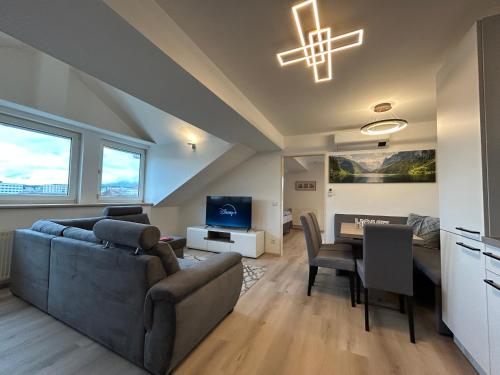 un soggiorno con un divano e un tavolo di Apartment KARAWANKENBLICK im HERZEN von VILLACH mit Privatgarage a Villach