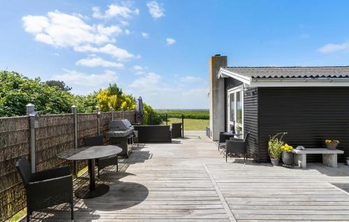a deck with a table and chairs and a fence at 2 Bedroom Amazing Home In Martofte in Martofte