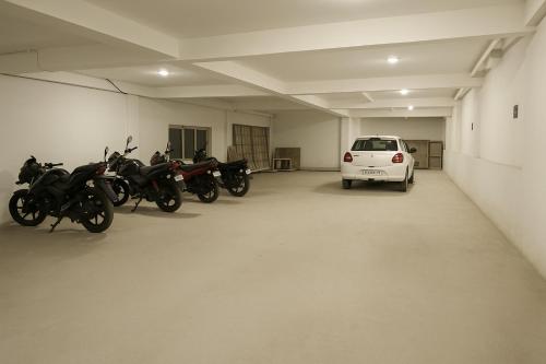 a parking lot with motorcycles and a car in it at Hotel The Heights in Haridwār