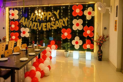 a table with a happy anniversary sign and flowers on a backdrop at Hotel The Heights in Haridwār