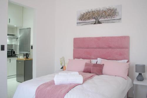 a bedroom with a bed with pink and white pillows at The View Apartment 3 in Lüderitz