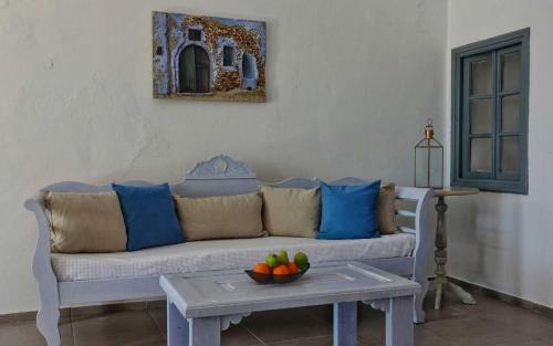 a living room with a couch and a table with a bowl of fruit at Ducato di Oia - Adults Only in Oia