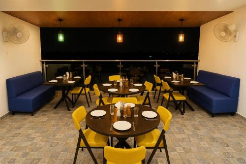 a dining room with tables and chairs and a large screen at Hotel The Heights in Haridwār