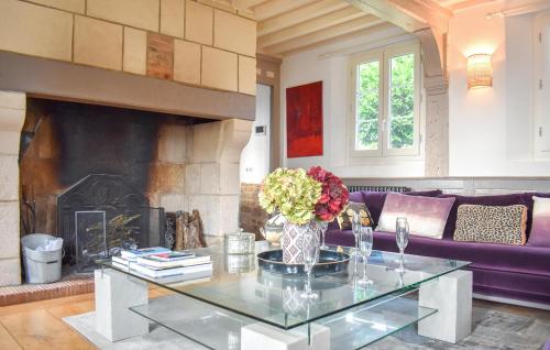 un salon avec un canapé violet et une cheminée dans l'établissement Chaumière Normande, à Le Breuil-en-Auge