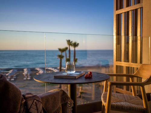 a table in a room with a view of the ocean at Nalu Resort & SPA Adults Only Hotel in Adelianos Kampos