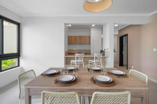 a dining room with a wooden table and chairs at Soma Bay - Incredible Seaside Apartment in Tamarin