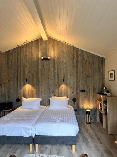 une chambre avec un lit et un mur en bois dans l'établissement La station en Drôme Provencale, à Vesc