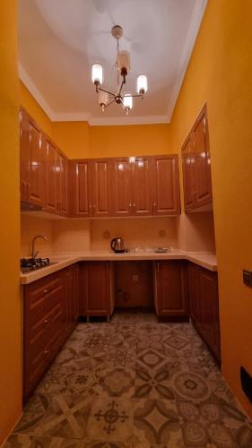 an empty kitchen with wooden cabinets and a chandelier at Grandview Boutique Hotel in Baku