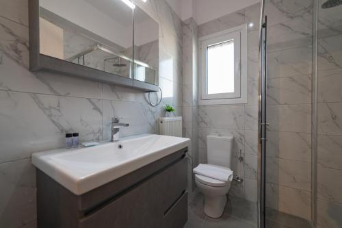 a bathroom with a sink and a toilet and a shower at Pantheon Suites Fasianos in Nafplio
