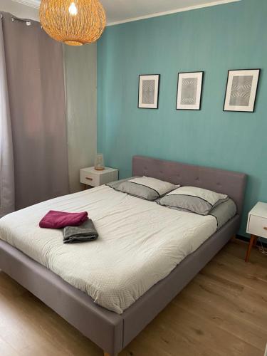 une chambre avec un grand lit avec un mur bleu dans l'établissement 2P cosy plein centre Antibes, à Antibes