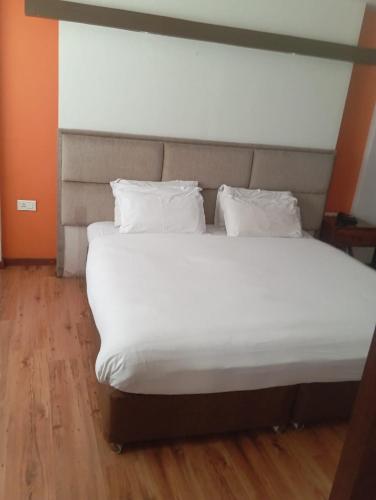 a large bed with white sheets and pillows at B N Hotel & Restaurant in Rāmechhāp
