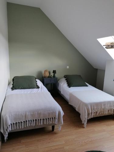 two beds sitting next to each other in a bedroom at Chambres d'hôtes Kersonan in Saint-Jean-Brévelay