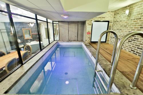 a large swimming pool in a room with windows at Daegu February Hotel Hwanggeum in Daegu