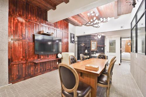 a dining room with a table and a flat screen tv at Daegu February Hotel Hwanggeum in Daegu
