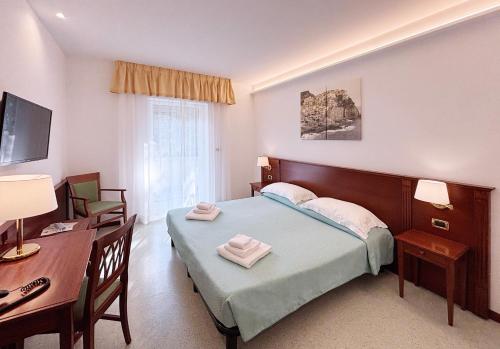a bedroom with a bed and a desk and a table at Hotel Villa Adriana in Monterosso al Mare