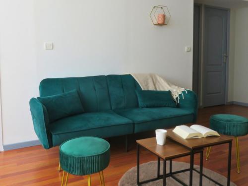 - un canapé vert dans le salon avec une table et des chaises dans l'établissement Appartement rénové 2 chambres 55m2 Parking Privé et Wifi, à Troyes