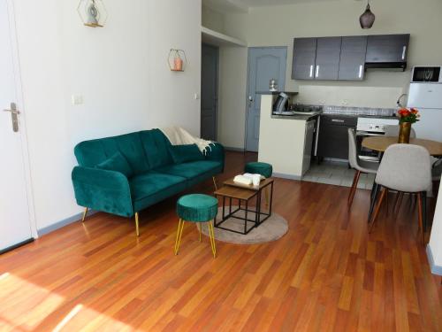 un salon avec un canapé vert et une cuisine dans l'établissement Appartement rénové 2 chambres 55m2 Parking Privé et Wifi, à Troyes