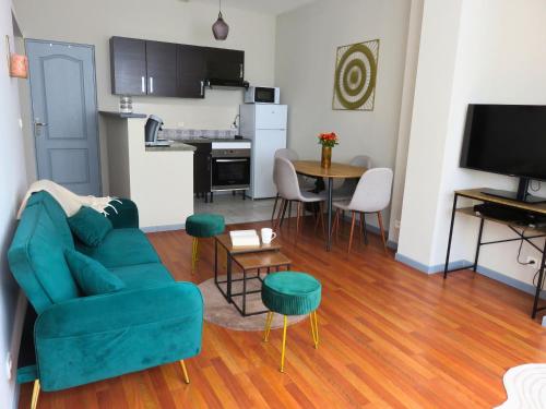 un salon avec un canapé bleu et une table dans l'établissement Appartement rénové 2 chambres 55m2 Parking Privé et Wifi, à Troyes