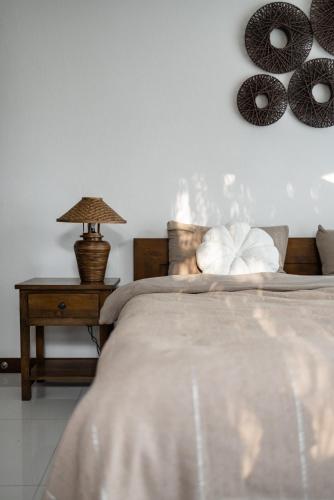 a bedroom with a bed and a table with a lamp at Luxury 3 BDR Jungle Villa - Infinity Pool & Seaview in Amphoe Koh Samui