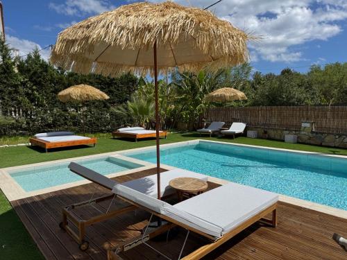 a pool with a chair and an umbrella next to it at NikLuDin suites & studios in Laganas