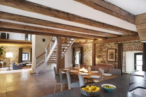 a kitchen and dining room with wooden ceilings and a table and chairs at Uroczysko Siedmiu Stawów Spa by L'Occitane in Gola Dzierżoniowska