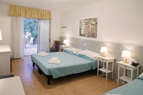 a bedroom with two beds and a door to a patio at Hotel Villa Adriana in Monterosso al Mare