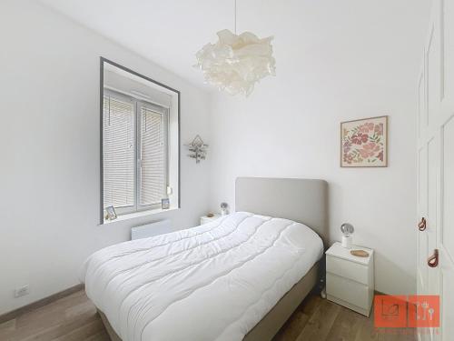 une chambre blanche avec un lit et une fenêtre dans l'établissement Pause Pastel, à Wimereux