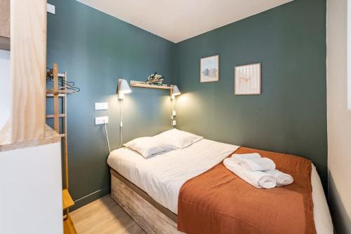 une chambre avec un lit avec deux serviettes dessus dans l'établissement Saint-Enogat - Cosy et rénové - Plage à 400m, à Dinard