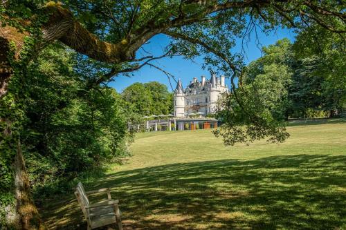 a park with a bench in front of a castle at Domaine de la Tortinière in Montbazon