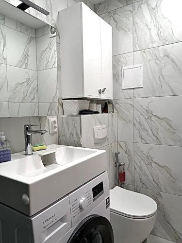a bathroom with a sink and a washing machine at Ąžuolų giraitėje 2 bedroom apartments in Klaipėda