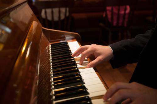 a person playing a piano in a room at Le Château de la Tour in Gouvieux