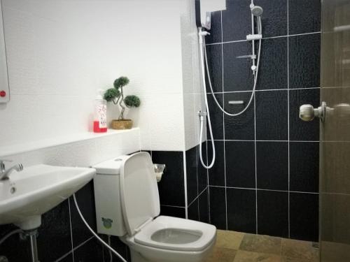 a bathroom with a shower and a toilet and a sink at Baan der Bruyn SHA in Jomtien Beach