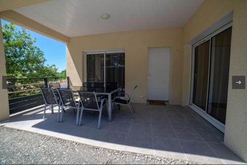 a patio with a table and chairs on a balcony at Gite LES BOUCHES ROUGES avec piscine privée in Vesseaux