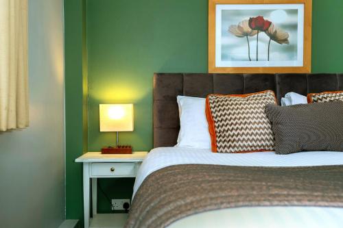 a bedroom with a bed and a table with a lamp at The Old Pheasant in Glaston