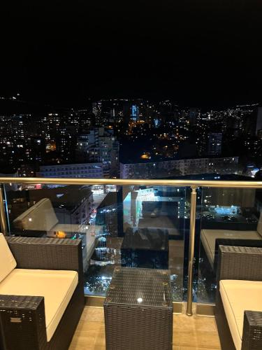 a balcony with a view of a city at night at Hotel Sky Station in Tbilisi City