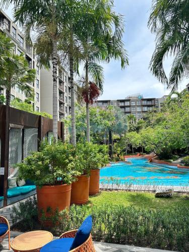 a resort with a swimming pool and palm trees at Joy house 1 bedroom Lahabana HuaHin in Hua Hin
