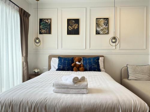 a teddy bear sitting on top of a bed with towels at Joy house 1 bedroom Lahabana HuaHin in Hua Hin