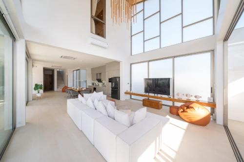 a living room with white furniture and large windows at 5BR Pool Villa with 20m Private Pool near Laguna Phuket - Trinity Villa by Warm Plus in Thalang