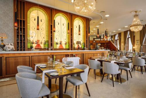 a restaurant with tables and chairs and a bar at Hotel Elizabeth in Trenčín
