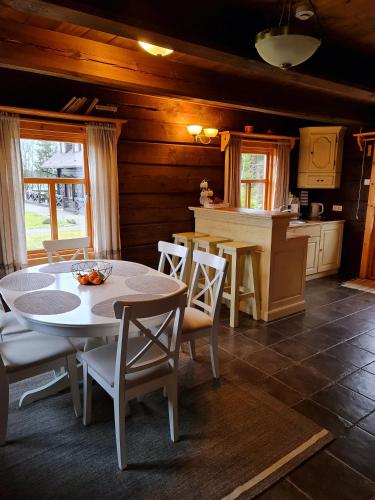 a kitchen and dining room with a table and chairs at Asvejos sodyba in Skirlėnai