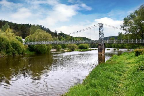 un ponte sopra un fiume con un treno che lo attraversa di Apartmány & Kemp Sázavský ostrov a Sázava