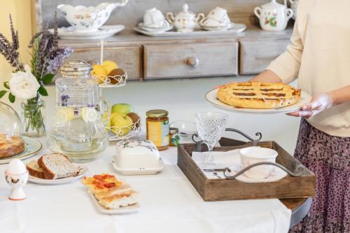 a woman holding a plate with a pie on a table at Agriturismo L’Orto di Muma in Gorleri